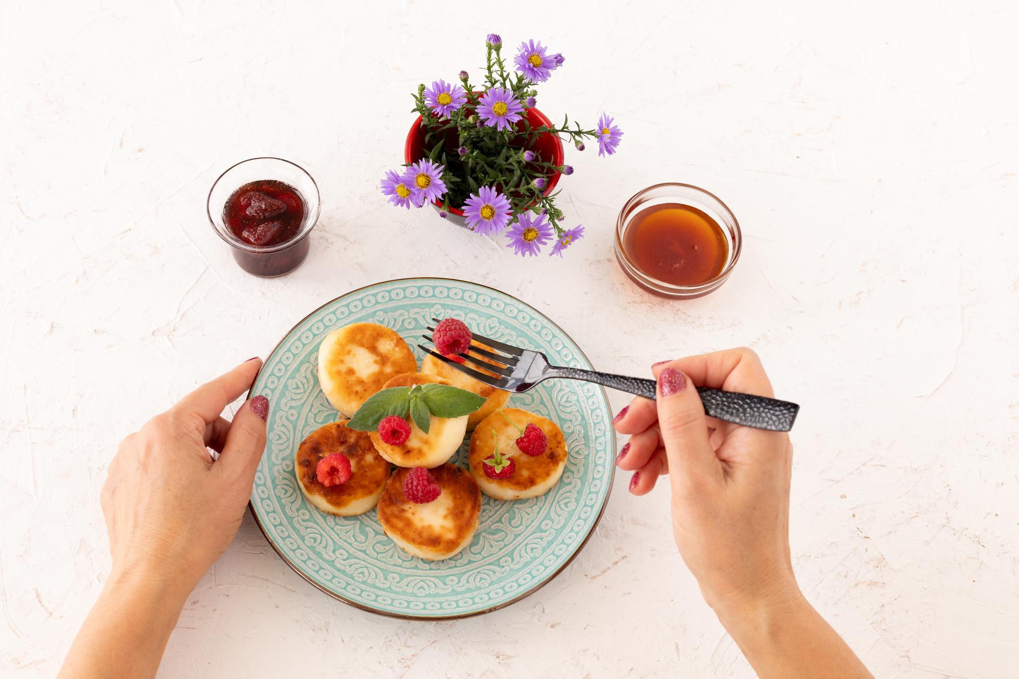 Hands plating a simple seasonal dish on a clean table